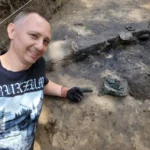 Dr. Andrzej Maciałowicz next to the Celtic helmet. Photo by Dr. Bartłomiej Kaczyński
