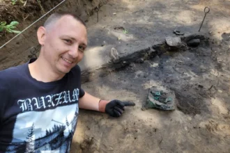 Dr. Andrzej Maciałowicz next to the Celtic helmet. Photo by Dr. Bartłomiej Kaczyński
