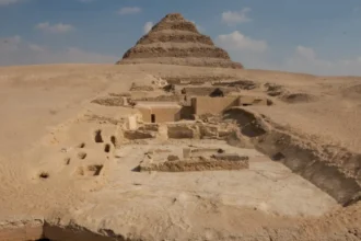 A view of the excavation site. In the foreground is the edge of the Dry Moat; in the background is the Step Pyramid; between them are the remains of the tombs of the Lower Necropolis (on the right) and the pits where the burials of the Upper Necropolis were located.