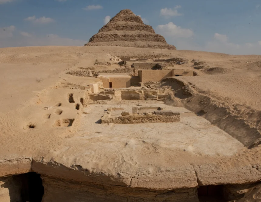 A view of the excavation site. In the foreground is the edge of the Dry Moat; in the background is the Step Pyramid; between them are the remains of the tombs of the Lower Necropolis (on the right) and the pits where the burials of the Upper Necropolis were located.