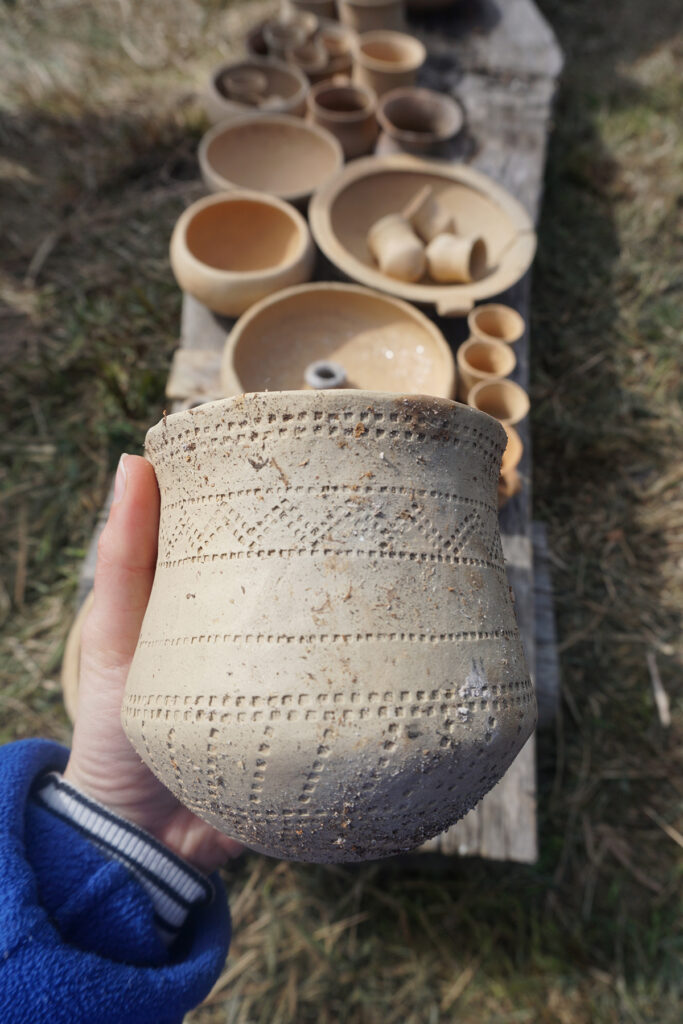 Rekonstrukcja pucharu dzwonowatego ze stanowiska 6 w Supraślu. Oryginalnie zachował się tylko fragment dolnej części naczynia, a ornament powyżej niezdobionego pasa jest propozycją rekonstrukcji. Fot. @ A. Cetwińska, CC BY-ND 4.0